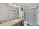 Bathroom with a granite vanity, framed mirror, decorative lighting, starfish decor, and a patterned shower curtain at 2293 Caspian Dr, Lakeland, FL 33805