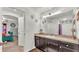 Bathroom with a granite vanity, framed mirror, decorative lighting, and a view into the bedroom at 2293 Caspian Dr, Lakeland, FL 33805