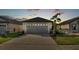 Two-car garage with decorative details and palm trees in a well-maintained front yard during dusk at 2293 Caspian Dr, Lakeland, FL 33805