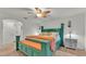 Spacious bedroom featuring a colorful teal bedframe, ceiling fan, and carpeted floor at 2293 Caspian Dr, Lakeland, FL 33805