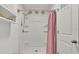 Shower with white tile surround, rainfall shower head, recessed shelf, and a pink shower curtain at 2293 Caspian Dr, Lakeland, FL 33805