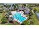 Aerial view of a large community pool, clubhouse, parking, tennis courts, and playground amenities at 2293 Caspian Dr, Lakeland, FL 33805