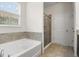 Bathroom featuring a large tub, shower, tile flooring, and a garden window at 2317 Bella Luna Cir, Lakeland, FL 33810