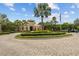 Beautiful community entrance with a lushly landscaped roundabout and stately architecture at 2317 Bella Luna Cir, Lakeland, FL 33810
