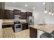 Kitchen features stainless steel appliances, dark wood cabinets, granite countertops, and a kitchen island at 2317 Bella Luna Cir, Lakeland, FL 33810
