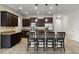 Spacious kitchen showcasing dark wood cabinets, stainless steel appliances, granite countertops, and an island at 2317 Bella Luna Cir, Lakeland, FL 33810