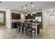 Open kitchen featuring granite countertops, dark wood cabinets, stainless steel appliances, and tile flooring at 2317 Bella Luna Cir, Lakeland, FL 33810