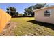 Backyard featuring a well-maintained lawn, new wood fence, and the exterior of the home at 2323 Ridgeview Dr, Lakeland, FL 33810