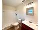 Clean, white bathroom featuring a shower and tub combo, toilet, vanity and mirror at 2323 Ridgeview Dr, Lakeland, FL 33810