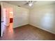 Bedroom featuring tile flooring, ceiling fan, and open doorway to a bathroom at 2323 Ridgeview Dr, Lakeland, FL 33810