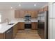 Modern kitchen featuring stainless steel appliances, wood cabinets, white countertops, and wood flooring at 2343 Northumberland Ct, Haines City, FL 33844