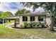 View of the home's exterior, covered parking area, and well-maintained landscaping in backyard at 2710 Fairmount Ave, Lakeland, FL 33803