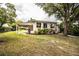 Backyard showcasing the exterior of the home, covered parking, and tropical landscaping at 2710 Fairmount Ave, Lakeland, FL 33803