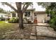 Backyard view featuring mature trees, a stone paver patio, and the rear of the home at 2710 Fairmount Ave, Lakeland, FL 33803