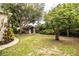 Spacious backyard featuring mature trees, lush greenery, and a charming storage shed at 2710 Fairmount Ave, Lakeland, FL 33803