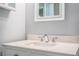 Bright bathroom featuring a marble vanity top, chrome fixtures, and a framed mirror at 2710 Fairmount Ave, Lakeland, FL 33803