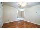 A sunny bedroom featuring wood-look floors and a window with a sheer curtain at 2710 Fairmount Ave, Lakeland, FL 33803