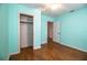 Bright bedroom with wood-look floors, ceiling fan, and a spacious open closet at 2710 Fairmount Ave, Lakeland, FL 33803