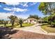 Charming home features a carport, front porch with chairs, and is surrounded by well-maintained landscaping at 2710 Fairmount Ave, Lakeland, FL 33803
