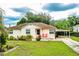 Traditional home with a cozy front porch and a convenient attached carport in a landscaped yard at 2710 Fairmount Ave, Lakeland, FL 33803