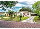 Traditional home featuring a covered carport, front porch, and a well-manicured lawn with palm trees at 2710 Fairmount Ave, Lakeland, FL 33803