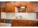 Close-up of kitchen featuring stainless steel appliances, wood cabinets, and ample counter space at 2710 Fairmount Ave, Lakeland, FL 33803
