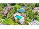 Aerial view featuring a refreshing community pool and tennis courts surrounded by tropical landscaping at 30 Aspen Dr # 30, Haines City, FL 33844