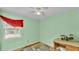 Bedroom with green walls featuring a ceiling fan, natural light, and desk with lamp at 306 Olmo Ct, Winter Haven, FL 33880