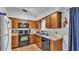 Functional kitchen featuring wood cabinets, laminate countertops, and black appliances at 306 Olmo Ct, Winter Haven, FL 33880