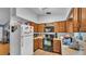 Functional kitchen featuring wood cabinets, laminate countertops, and black appliances at 306 Olmo Ct, Winter Haven, FL 33880