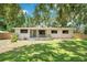 Charming single-story home features a well-manicured lawn and inviting front porch with seating, and a freshly painted exterior at 312 Palencia Pl, Lakeland, FL 33803
