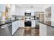 A modern kitchen features white cabinets, stainless steel appliances, and dark granite countertops at 312 Palencia Pl, Lakeland, FL 33803