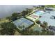 Aerial view of community amenities featuring tennis courts, pool, and a view of the lake at 3136 Langdon Ln, Winter Haven, FL 33884