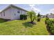 Lush backyard features a healthy tree, hedges, and well-maintained lawn extending to the home's exterior at 3136 Langdon Ln, Winter Haven, FL 33884