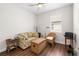 Bright bonus room with a sofa, side tables, wicker chair and dark wood flooring at 3136 Langdon Ln, Winter Haven, FL 33884
