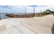 A concrete boat ramp with a wooden dock on a sunny day at 3136 Langdon Ln, Winter Haven, FL 33884