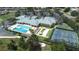 Aerial view of a clubhouse featuring a pool, hot tub, tennis court, shuffleboard, and parking at 3136 Langdon Ln, Winter Haven, FL 33884