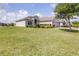 Landscaped front yard of a single-story home with a brick driveway and a two-car garage, set against a blue sky at 3136 Langdon Ln, Winter Haven, FL 33884