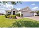 Well-maintained single-story home features manicured landscaping and a brick driveway leading to a two-car garage at 3136 Langdon Ln, Winter Haven, FL 33884