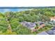 Expansive aerial view of a beautiful home nestled among lush trees, with a lake in the distance at 323 E Belvedere St, Lakeland, FL 33803