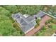 Detailed aerial view of the home with lush gardens, brick driveways, and mature trees surrounding it at 323 E Belvedere St, Lakeland, FL 33803