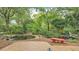 Relaxing backyard view with a koi pond, brick patio, lush greenery, and a quaint red bench at 323 E Belvedere St, Lakeland, FL 33803