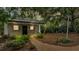 Quaint backyard featuring a brick playhouse with adjacent swing set surrounded by mature landscaping at 323 E Belvedere St, Lakeland, FL 33803