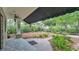 Covered backyard patio overlooking lush landscaping, a brick walkway, and a swing set at 323 E Belvedere St, Lakeland, FL 33803