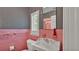 Pink checkered bathroom with checkered wallpaper and a vintage sink and mirror at 323 E Belvedere St, Lakeland, FL 33803