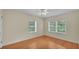 Sunny bedroom with hardwood floors and two large windows overlooking the yard at 323 E Belvedere St, Lakeland, FL 33803