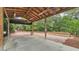 Open carport area with a wooden ceiling, ceiling fans, brick-paved surroundings, and lush landscaping at 323 E Belvedere St, Lakeland, FL 33803