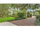 Brick driveway leading to home surrounded by mature landscaping and lush greenery at 323 E Belvedere St, Lakeland, FL 33803
