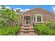 Inviting brick home entrance with arched doorway, decorative window, and well-maintained greenery at 323 E Belvedere St, Lakeland, FL 33803