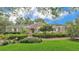Charming brick home with manicured lawn, lush landscaping, and a welcoming front entrance at 323 E Belvedere St, Lakeland, FL 33803